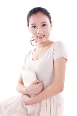 Genç bir kadın kitaba sarılıyor.