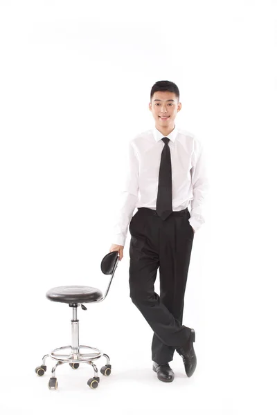 Porträt Eines Jungen Bisinessmanns Der Neben Einem Stuhl Steht — Stockfoto