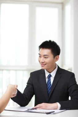 Tokalaşmak için el sıkışan genç iş adamlarının portresi