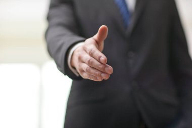 Tokalaşmak için el sıkışan genç iş adamlarının portresi.