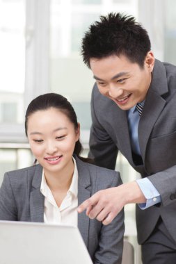 İşadamı ve iş kadını bilgisayarda çalışıyor