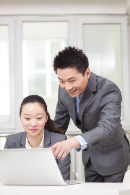 İşadamı ve iş kadını bilgisayarda çalışıyor