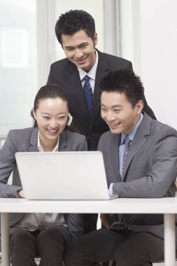 Bir grup iş adamı tartışıyorlar, bilgisayar üzerinde çalışıyorlar.