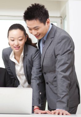 Bir grup iş adamı tartışıyorlar, bilgisayar üzerinde çalışıyorlar.