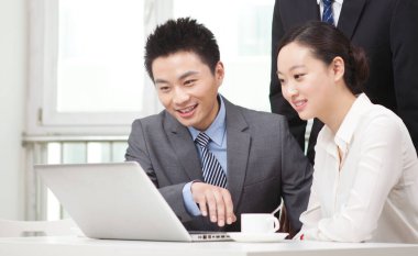 Bir grup iş adamı tartışıyorlar, bilgisayar üzerinde çalışıyorlar.