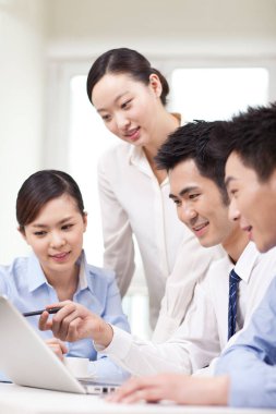 Bir grup iş adamı tartışıyorlar, bilgisayar üzerinde çalışıyorlar.