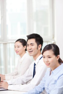	Executives sitting at conference table (focus on man in foreground)	