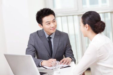 Bir grup iş adamı ofiste tartışıyor.