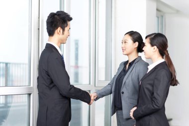 Ofis girişinde bir grup iş arkadaşı tartışılıyor.