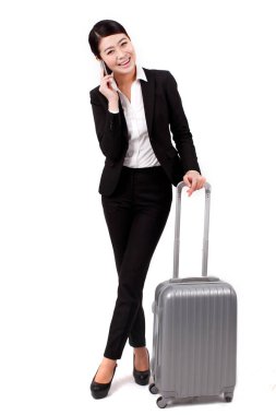 İş kadını cep telefonu kullanıyor, bavul çekiyor.