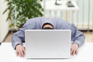 Ofiste dizüstü bilgisayar kullanan bir iş adamının yakın çekimi.