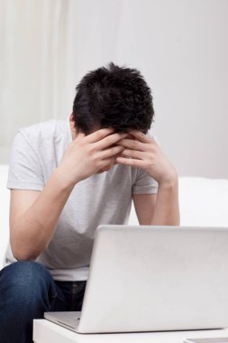 Kanepede dizüstü bilgisayar kullanan neşeli bir iş adamı.