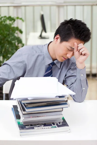 Egy Férfi Stresszesnek Tűnik Miközben Asztalánál Dolgozik — Stock Fotó