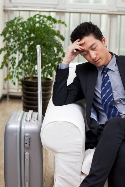 	Businessman resting head on pile of boot	