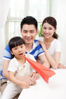 Üç çocuklu kağıt uçak ailesi.