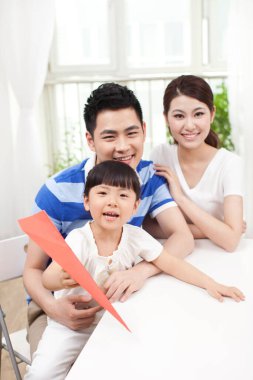 Üç çocuklu kağıt uçak ailesi.