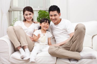 Koltukta oturan genç bir aile.