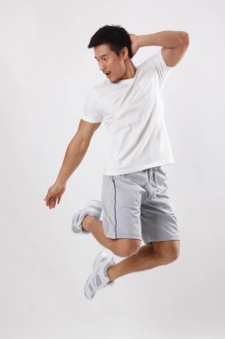 Gündelik kıyafetlerle atlayan genç bir adam.