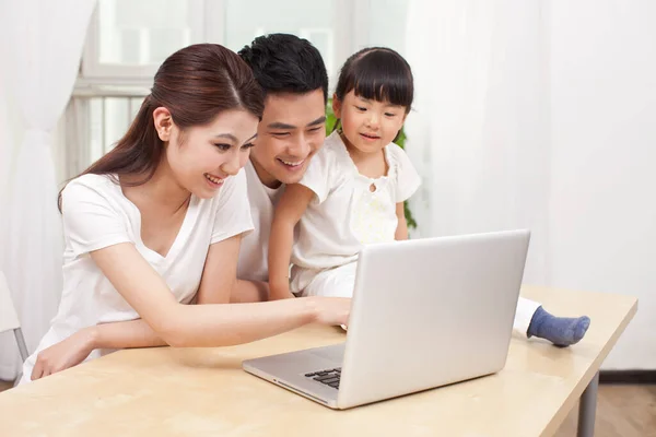 小女孩和她的父母一起使用笔记本电脑 — 图库照片