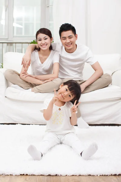 一个年轻的中国女孩在客厅里 背景是父母 — 图库照片