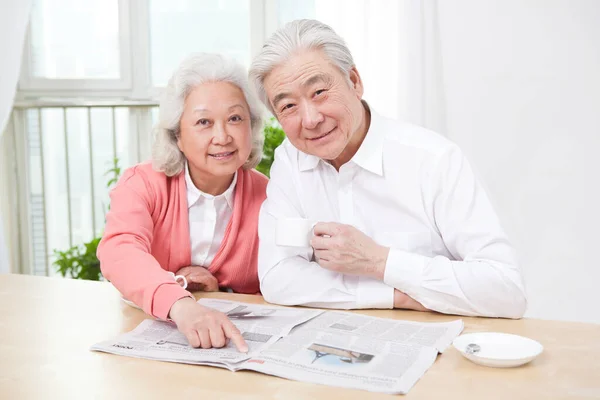 Senior couple reading newspaper