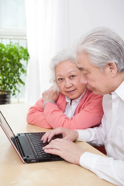 Senior couple using laptop