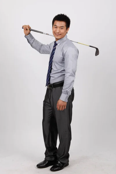 一个拿着高尔夫球楔子的年轻商人 — 图库照片