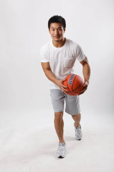 一个穿着休闲装打篮球的年轻人 — 图库照片