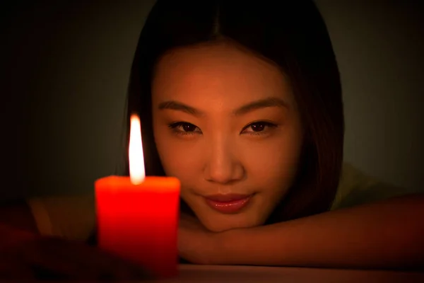 Young woman holding a red candle