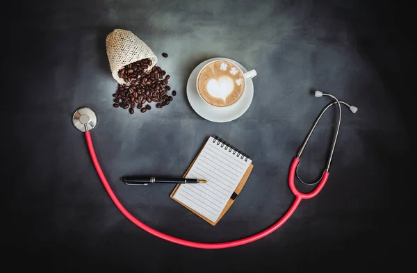 hot late art with coffee beans and stethoscope on background.