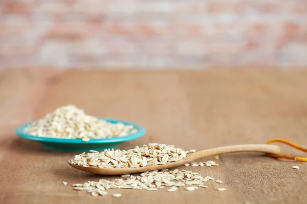 Oats flakes in wood spoon on wood table
