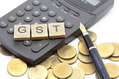Word Gst ahşap alfabe bloklar üzerinde hesap makinesi. Seçici odak alan sığ derinliği. Maliye ve vergi kavramları.