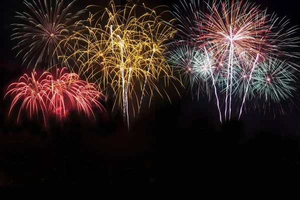 Färgglada fyrverkerier i holiday nyår festival på svart himmel. — Stockfoto