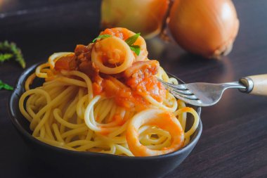 Spagetti makarna salça ve fesleğen karanlık masada plaka üzerinde