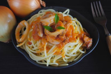Spagetti makarna salça ve fesleğen karanlık masada plaka üzerinde