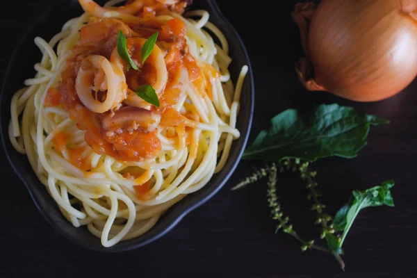 토마토 소스와 어두운 테이블에 접시에 스파게티 파스타 — 스톡 사진
