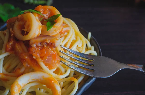 Spagetti makarna salça ve fesleğen karanlık masada plaka üzerinde