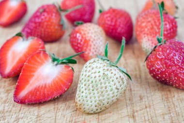 Çilek grup ahşap arka plan üzerinde.