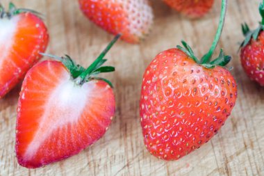 Çilek grup ahşap arka plan üzerinde.