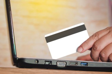 kredi kartı online alışveriş kavramı için laptop üzerinde tutan el.