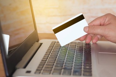 kredi kartı online alışveriş kavramı için laptop üzerinde tutan el.