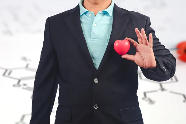 Business man holding red heart ball for Valentine day.