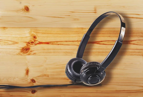 Auriculares en el suelo de madera de pino o fondo de mesa de escritorio . —  Fotos de Stock