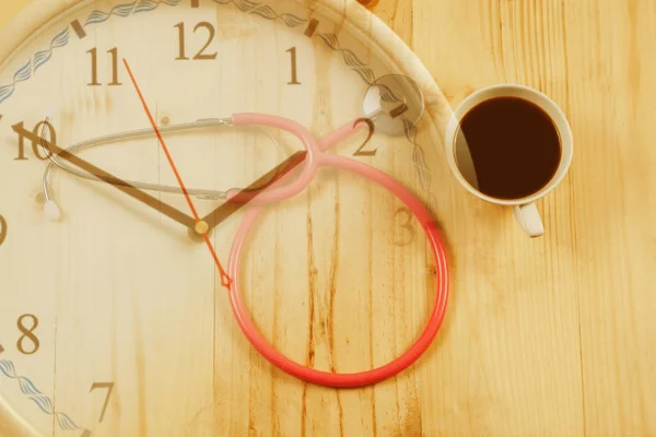 Rosafarbenes Stethoskop ist medizinisches Gerät mit heißem Kaffee — Stockfoto