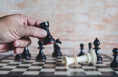 rekabet oyunu kazanmak için satranç figürü hareketli işadamının el.