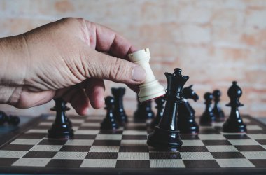 rekabet oyunu kazanmak için satranç figürü hareketli işadamının el.