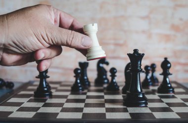 rekabet oyunu kazanmak için satranç figürü hareketli işadamının el.