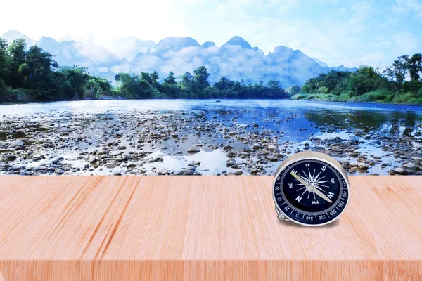 Oude kompas op houten wandeling en rivier met blauwe lucht. — Stockfoto