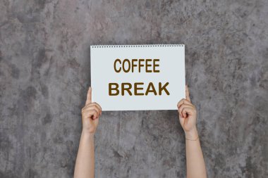 Kahve Break agai yazan bir kartpostal yüksek tutan kadın elleri