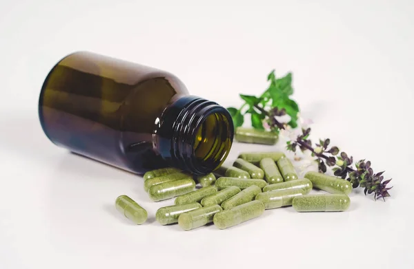 Alternative herb capsule spill out of bottle ,health concept. — Stock Photo, Image